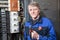 Senior electrician with pliers in his hands standing near high voltage panel