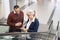 Senior entrepreneur talking with mature businessman on escalator during business trip