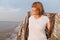 Senior european woman smiling while walking on beach