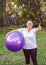 Senior exercise - thumb up for healthy exercising woman with fitness balls in park