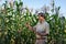 A senior, experienced Asian male farmer or agronomist is working in a corn field