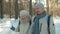 Senior family walking in forest on sunny winter day talking and laughing together