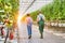 Senior farmer carrying tomatoes in crate while young female supervisor holding report