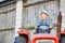 Senior farmer wearing hat while driving tractor