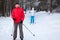 Senior father with adult daughter skiing on cross-country skis in winter forest