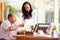 Senior Father Discussing Document With Adult Daughter