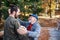 Senior father and his son on walk in nature, hugging and talking.