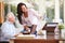 Senior Father Looking At Photo In Frame With Adult Daughter