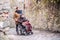 Senior father in wheelchair and son on a walk in old town.