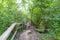 Senior female hiker climbing ecological stairs up steep slope