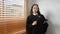 Senior female judge in robe gown uniform holding a gavel in hand and looking confidently to camera. Lawyer, justice and