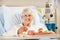 Senior Female Patient Eating Meal In Hospital Bed