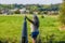 Senior female tourist standing at border marker between Belgium and Holland