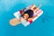 Senior female woman with bright sun glasses lies on a swimming pool inflatable icecream shaped float