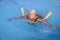 Senior female woman holds on to a flotation device on a swimming pool to learn how to swim