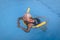 Senior female woman holds on to a flotation device on a swimming pool to learn how to swim