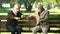 Senior friends talking and laughing, sitting on bench in park, happy memories