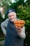 Senior gardener with a pumpkin. Farmer 87 years old enjoys the harvest of pumpkins in the garden. Cheerful active old