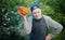 Senior gardener with a pumpkin. Farmer 87 years old enjoys the harvest of pumpkins in the garden. Cheerful active old man in