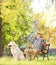 Senior gentleman on bench with his dog relaxing in a park