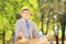 Senior gentleman meditating seated on a grass in a park