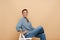 Senior ginger woman smiling at camera while sitting on chair