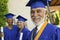 Senior graduate smiling outside with others behind