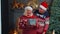 Senior grandfather covering eyes of old grandmother with surprise Christmas gift present box at home