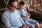 Senior grandfather and granddaughter starring at smartphones indoors