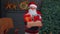 Senior grandfather parodies Santa Claus presenting Christmas gift box, holidays celebration at home