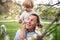 Senior grandfather with toddler grandson standing in nature in spring.