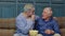 Senior grandfather and young men watching football match on television, males generations family