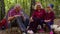 Senior grandmother grandfather granddaughter telling funny stories fairy tales over campfire in wood