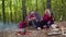 Senior grandmother grandfather granddaughter telling funny stories fairy tales over campfire in wood