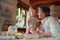 Senior grandmother with small toddler boy making cakes at home.