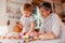 Senior grandmother with small toddler boy making cakes at home.