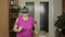 Senior grandmother in virtual headset glasses watching 3D video in VR helmet and running at home
