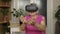 Senior grandmother woman in virtual headset glasses watching 3d video in 360 vr helmet at home