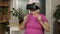 Senior grandmother woman in virtual headset glasses watching 3d video in 360 vr helmet at home