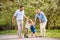 Senior grandparents with toddler grandchildren walking in nature in spring.