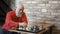 Senior gray-haired man play chess with himself