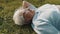 Senior gray haired woman with headphones lying on the grass and listening to the music