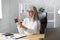 Senior grey-haired beautiful woman using smartphone and smiling. Happy businesswoman using mobile phone apps, texting