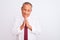 Senior grey-haired businessman wearing elegant tie over isolated white background praying with hands together asking for