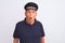 Senior grey-haired man wearing black polo and captain hat over isolated white background afraid and shocked with surprise