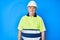 Senior grey-haired man wearing worker reflective t shirt and hardhat with a happy and cool smile on face