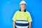 Senior grey-haired man wearing worker reflective t shirt and hardhat looking to side, relax profile pose with natural face and