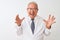 Senior grey-haired scientist man wearing coat standing over isolated white background crazy and mad shouting and yelling with