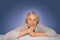 Senior grey haired woman dreaming on blue background