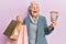 Senior grey-haired woman holding shopping bags and australia dollars celebrating crazy and amazed for success with open eyes